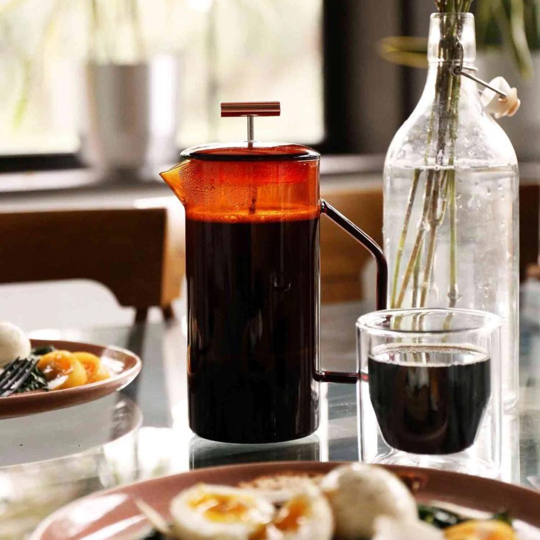 orange french press at breakfast table