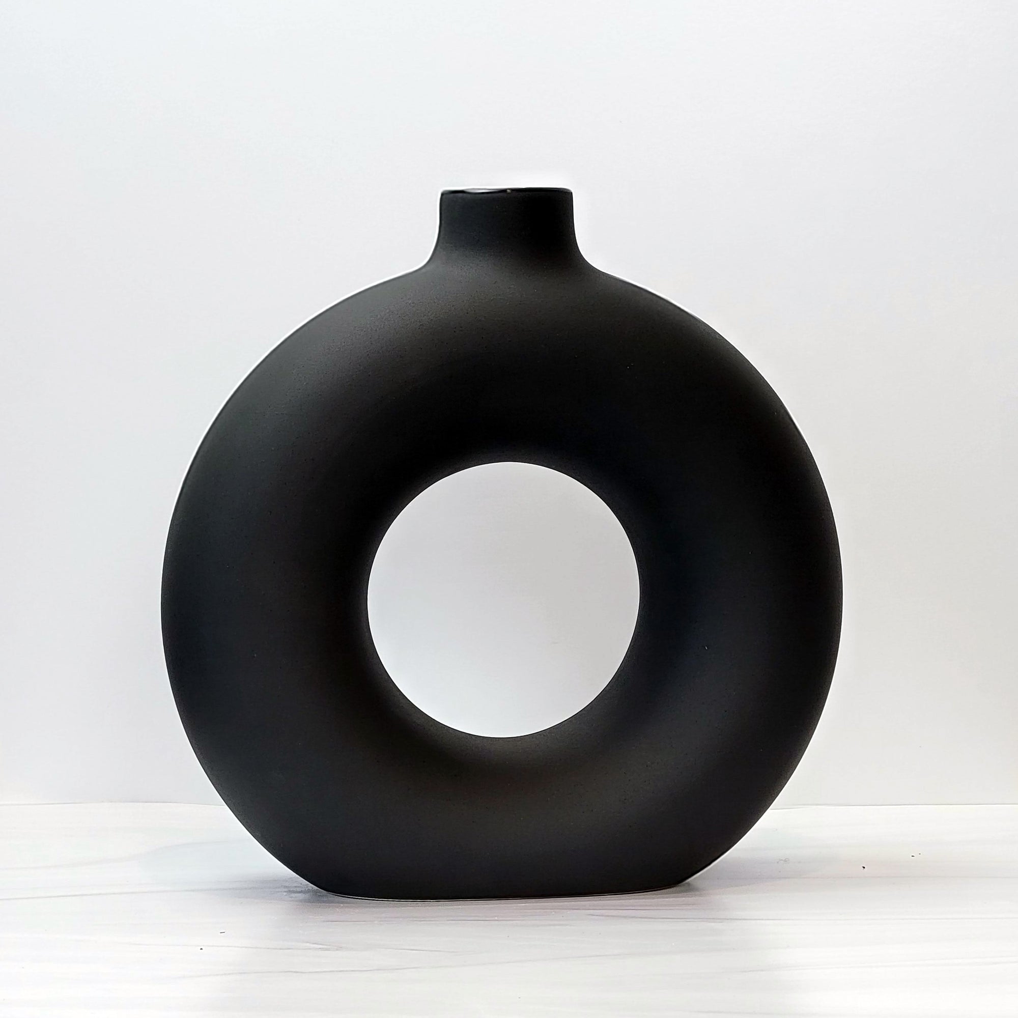 Large and small black doughnut-shaped Otto vases.