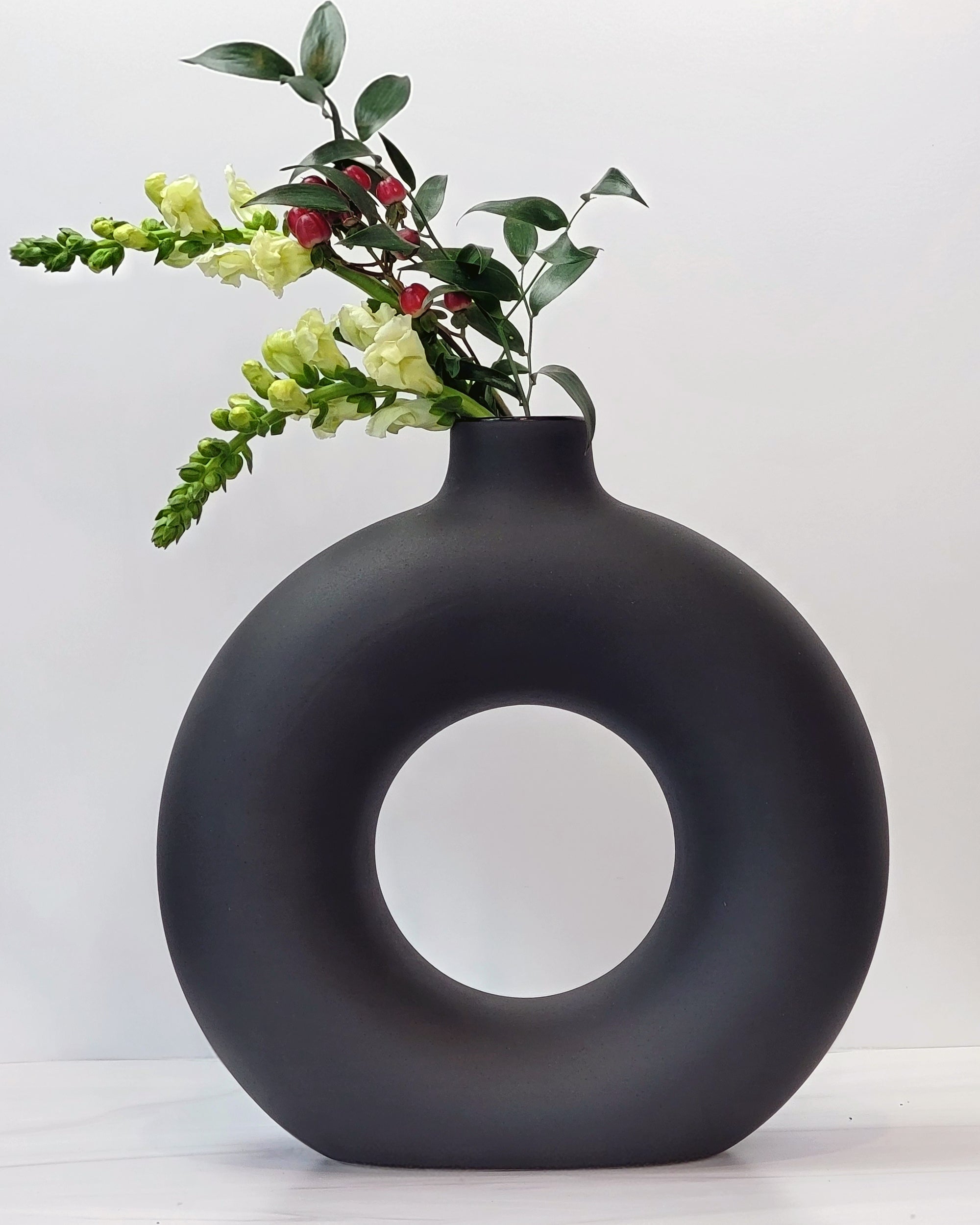 Large black doughnut-shaped Otto vase.