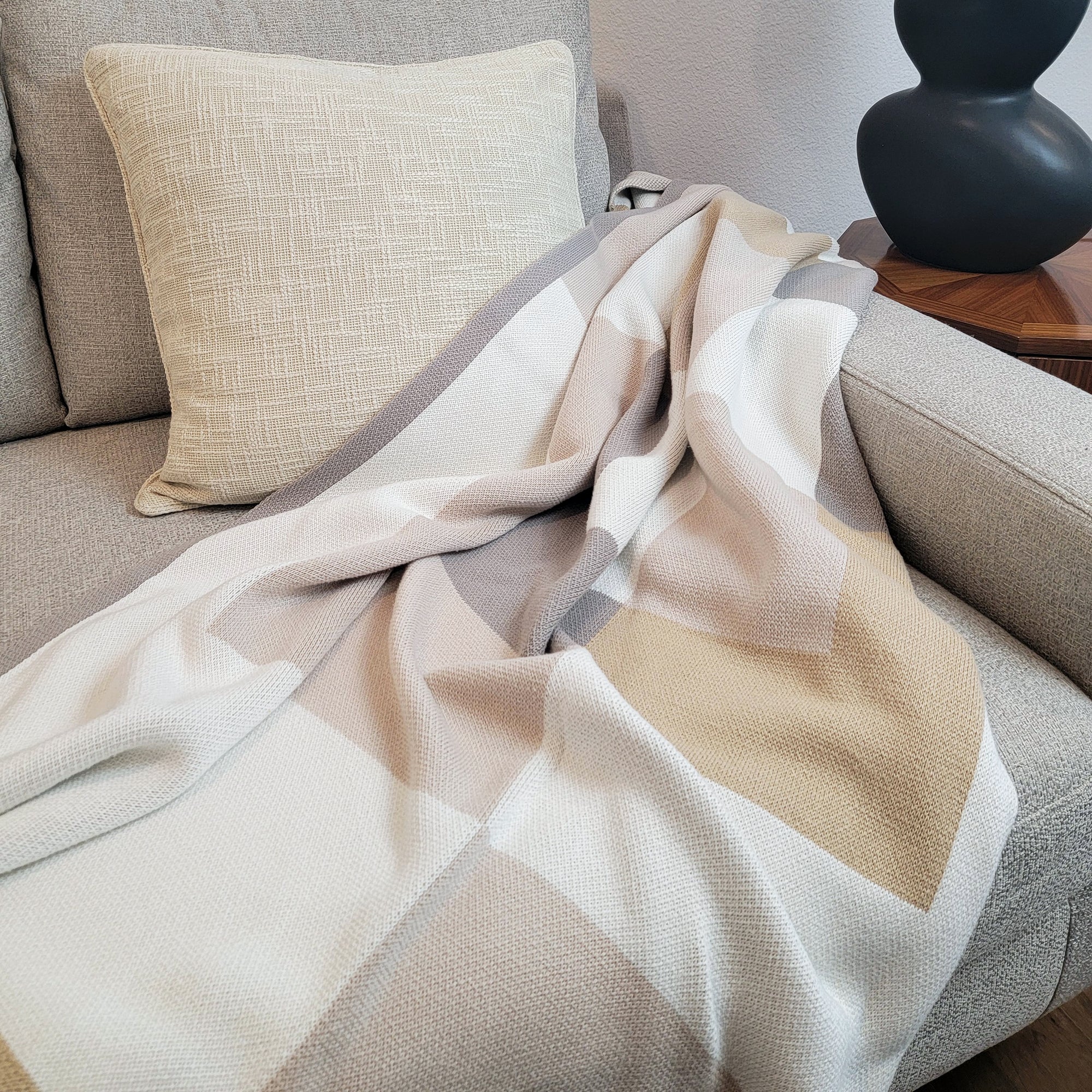 Neutral geometric throw blanket and cream textured cotton pillow